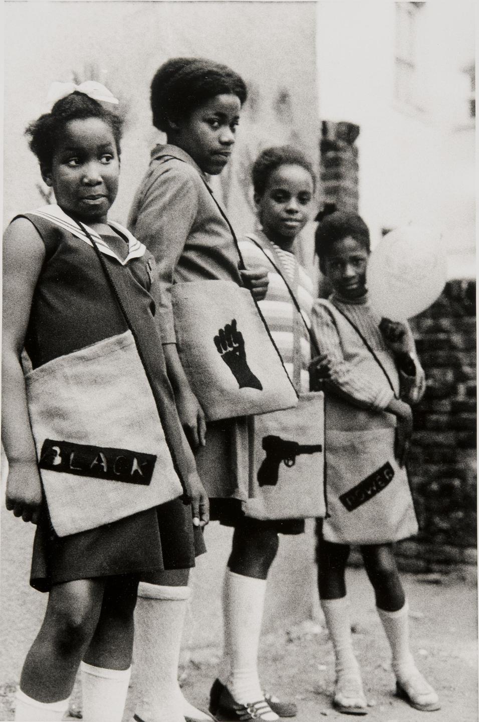 Eine Fotografie zeigt eine Gruppe junger Mädchen mit dem Symbol der Bewegung "Black Panther" auf ihren Schultaschen 1970.