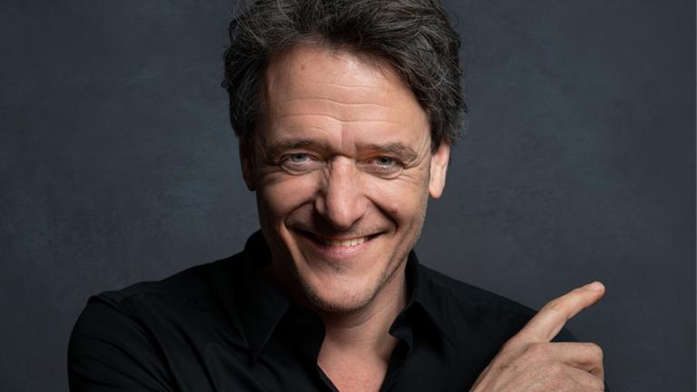 Der österreichische Musikkabarettist Christof Spörk lacht in die Kamera Der österreichische Musikkabarettist Christof Spörk lacht in die Kamera