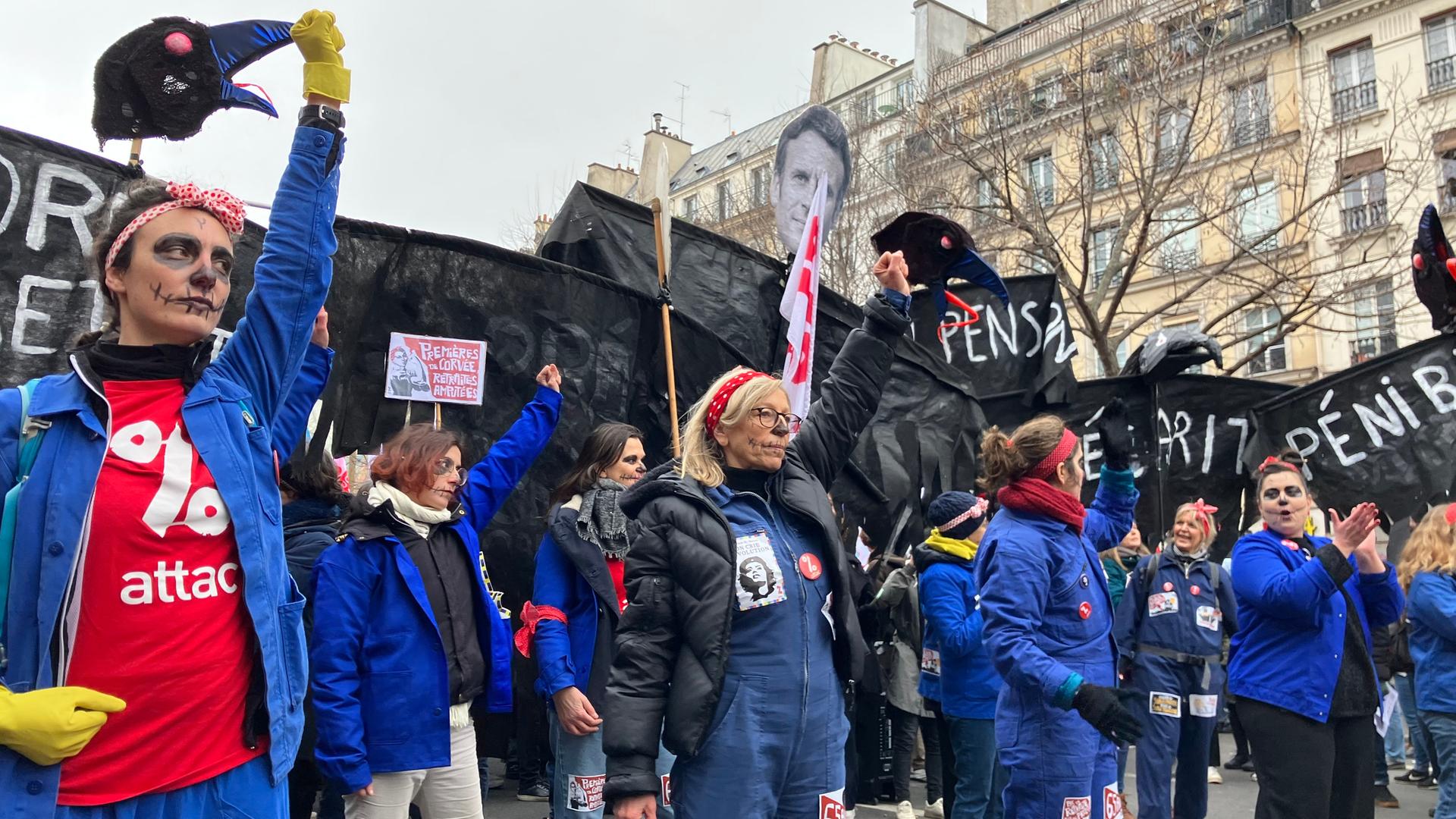 Mehrere Demonstrantinnen und Demonstranten halten eine Faust und Banner gegen die von der französischen Regierung geplanten Rentenreform in die Luft. 