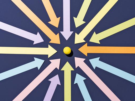 Pfeile in verschiedenen Farben konzentrieren sich auf einen Punkt in der Mitte.