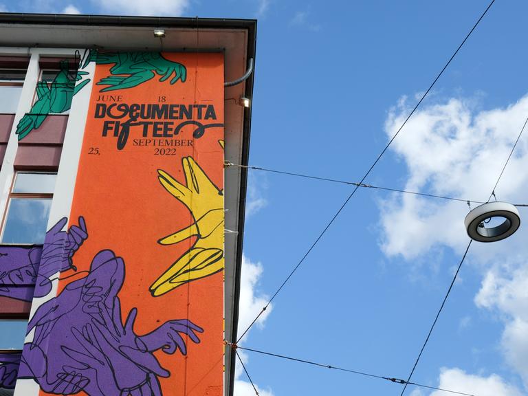 Der Schriftzug "documenta fifteen" und das Logo vom indonesischen Kuratorenkollektiv Ruangrupa prangt an der Fassade eines ehemaligen Sportgeschäftes in der Kasseler Innenstadt.