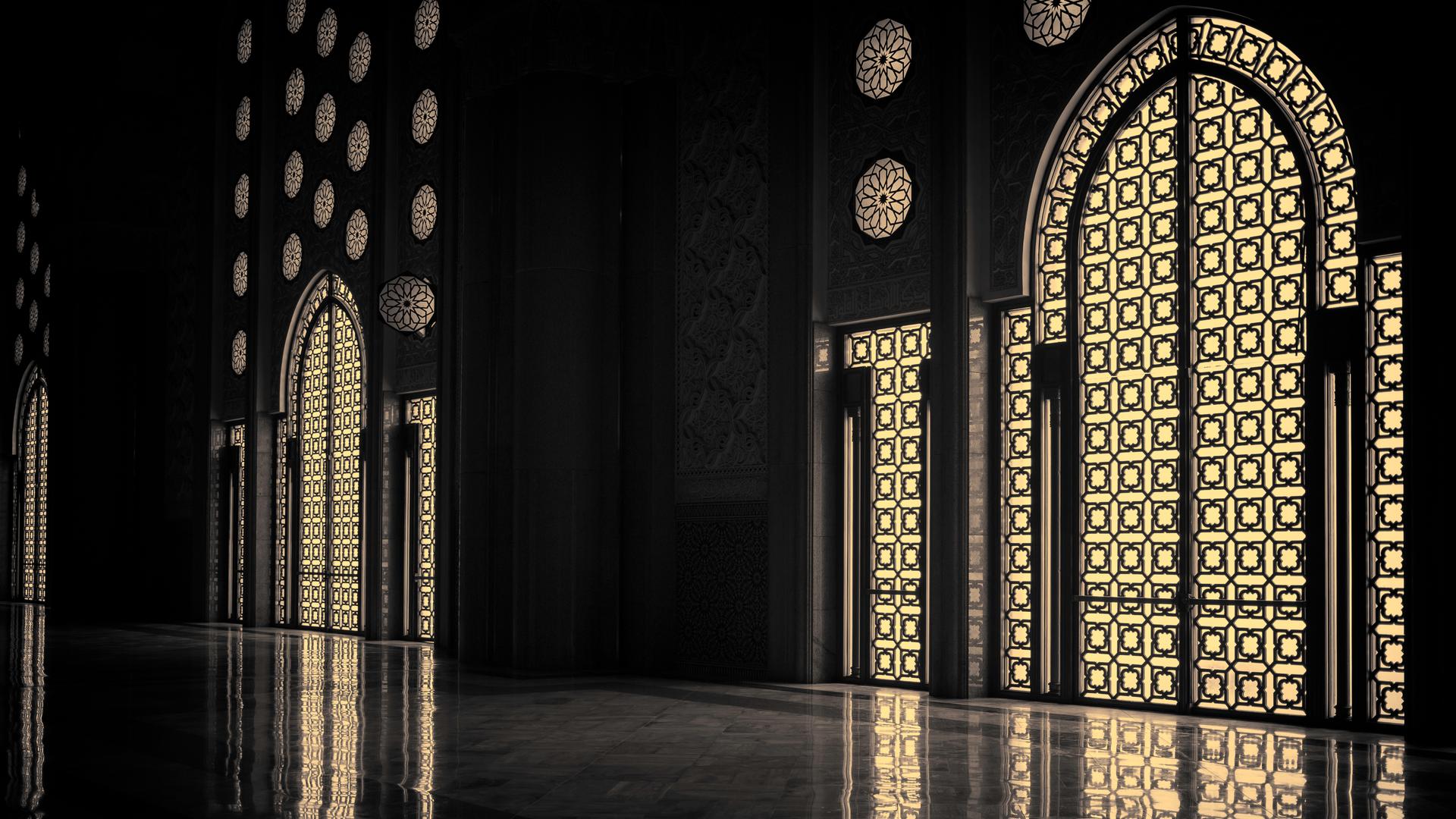 Im Inneren einer Moschee, das Licht fällt geheimnisvoll durch die reichverzierten Fenster.