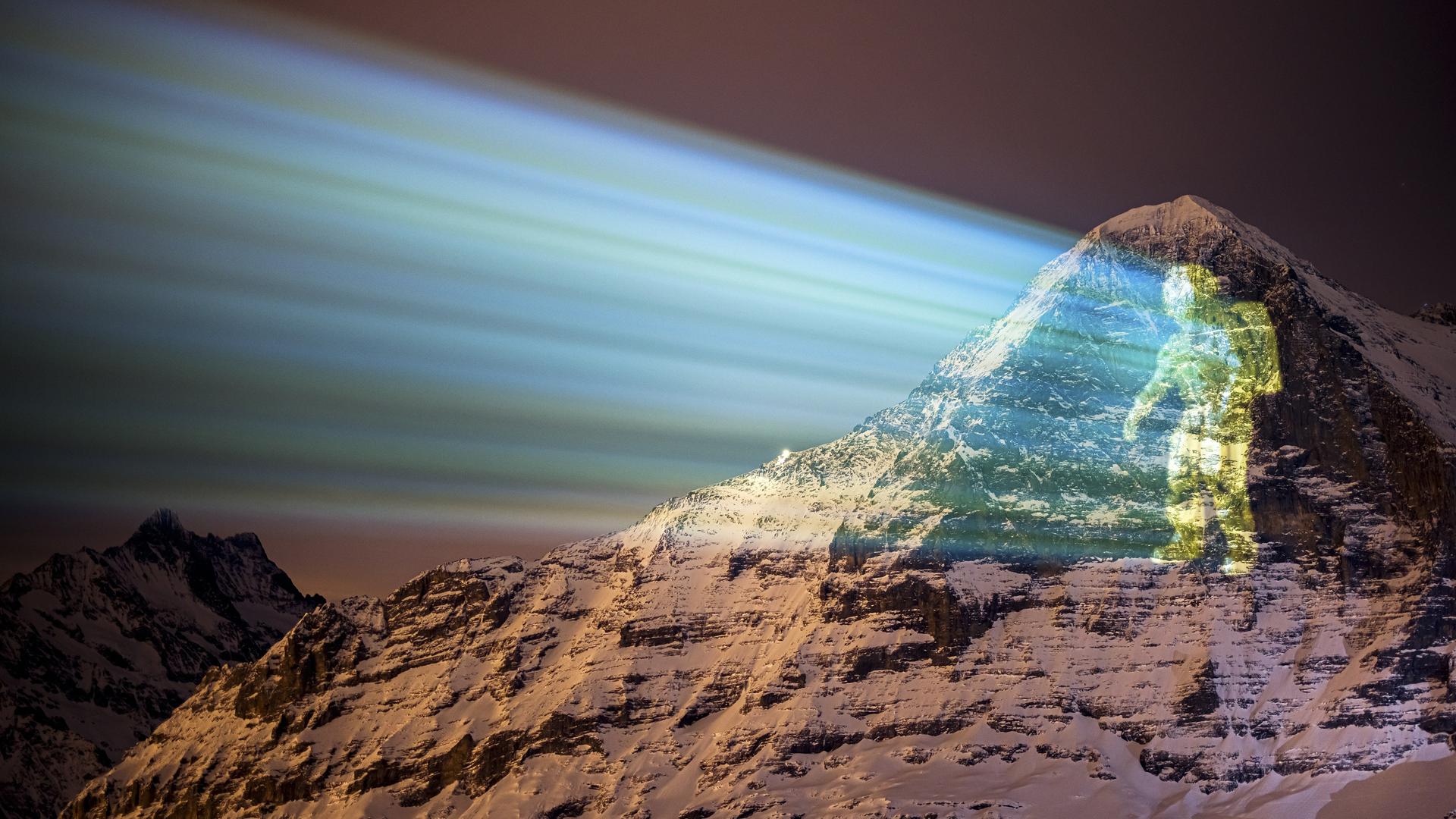 Eine riesige Projektion eines Astronauten auf die Eiger-Nordwand des Schweizer Lichtkünstlers Gerry Hofstetter, vom Alpenort Mannlichen in der Schweiz aus gezeigt. Eine riesige Projektion eines Astronauten auf die Eiger-Nordwand des Schweizer Lichtkünstlers Gerry Hofstetter, vom Alpenort Mannlichen in der Schweiz aus gezeigt.