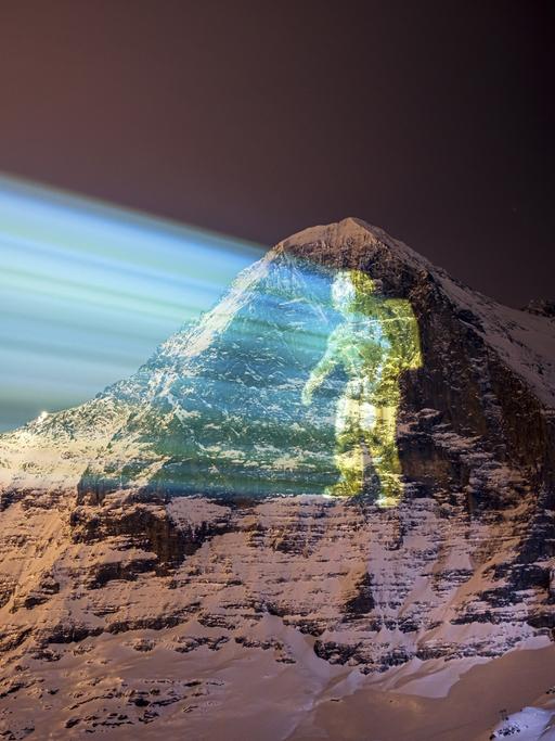 Eine riesige Projektion eines Astronauten auf die Eiger-Nordwand des Schweizer Lichtkünstlers Gerry Hofstetter, vom Alpenort Mannlichen in der Schweiz aus gezeigt.