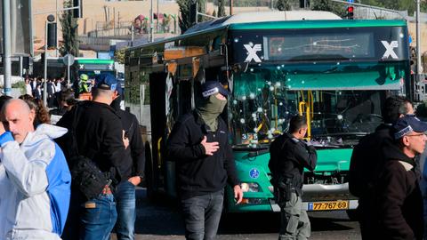 Israelische Sicherheitskräfte und Ermittler stehen an einem Bus, der durch die Explosion beschädigt wurde.