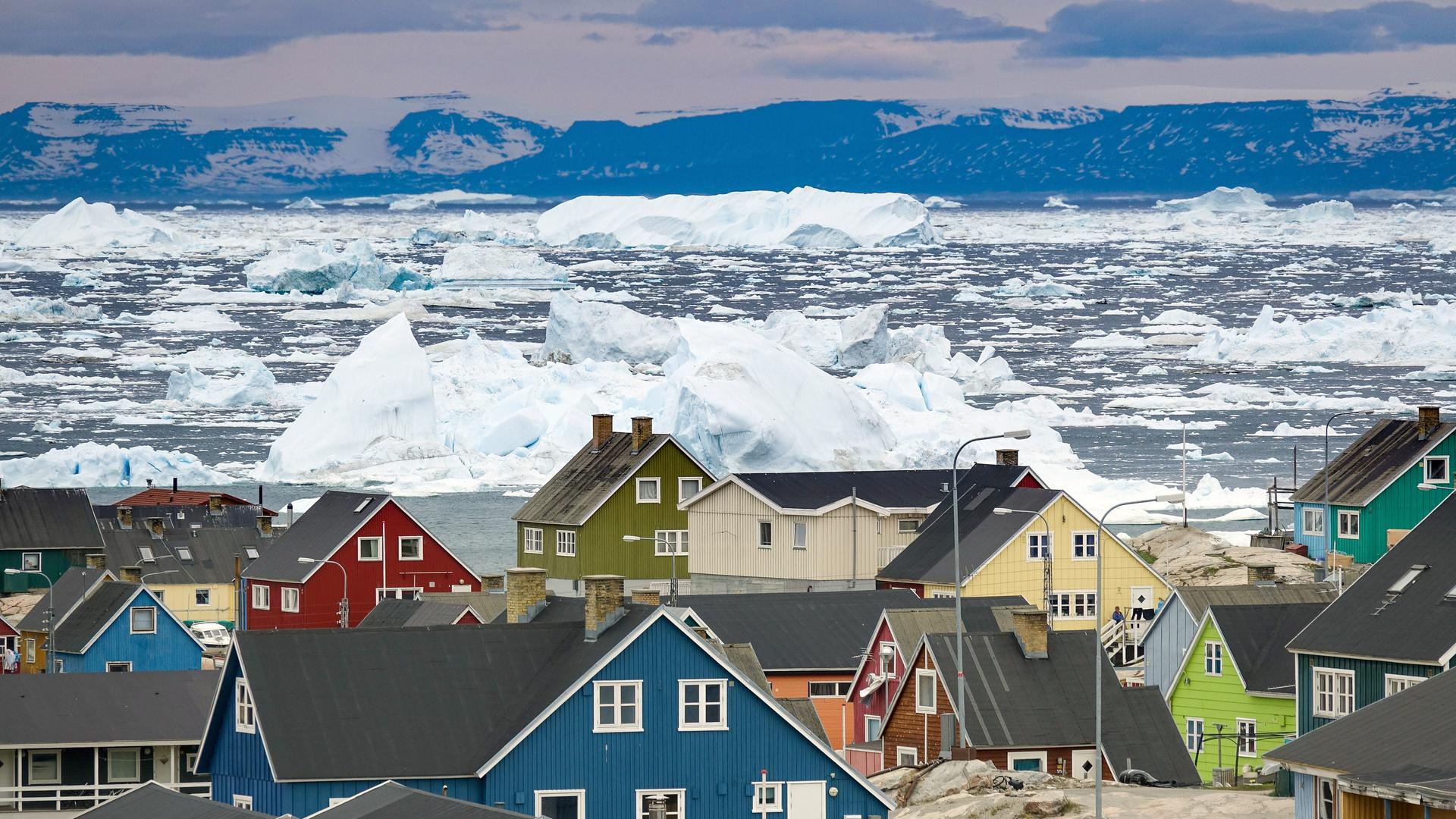 Grönland, Dänemark: Bunte Häuser der Küstenstadt Ilulissat im westlichen Grönland. Die Stadt liegt am Ilulissat-Eisfjord, der für besonders große Eisberge in der Diskobucht bekannt ist Grönland, Dänemark: Bunte Häuser der Küstenstadt Ilulissat im westlichen Grönland. Die Stadt liegt am Ilulissat-Eisfjord, der für besonders große Eisberge in der Diskobucht bekannt ist