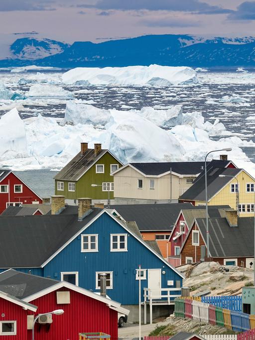 Grönland, Dänemark: Bunte Häuser der Küstenstadt Ilulissat im westlichen Grönland. Die Stadt liegt am Ilulissat-Eisfjord, der für besonders große Eisberge in der Diskobucht bekannt ist