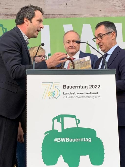Links vom Rednerpult auf dem Bauerntag in Stuttgart steht Bauer Stefan Kerner, rechts steht Landwirtschaftsminister Cem Özdemir.