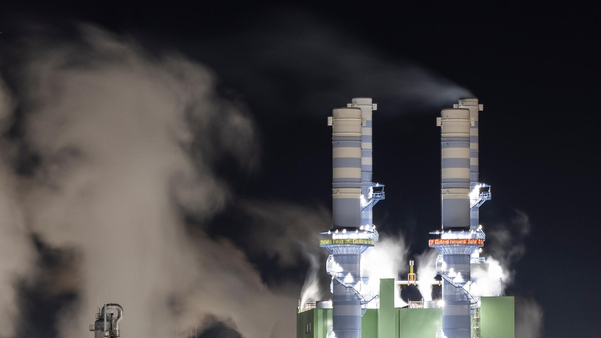 Dampf steigt bei Nacht aus beleuchteten Industrieschornsteinen des Industriepark Höchst auf. Dampf steigt bei Nacht aus beleuchteten Industrieschornsteinen des Industriepark Höchst auf.
