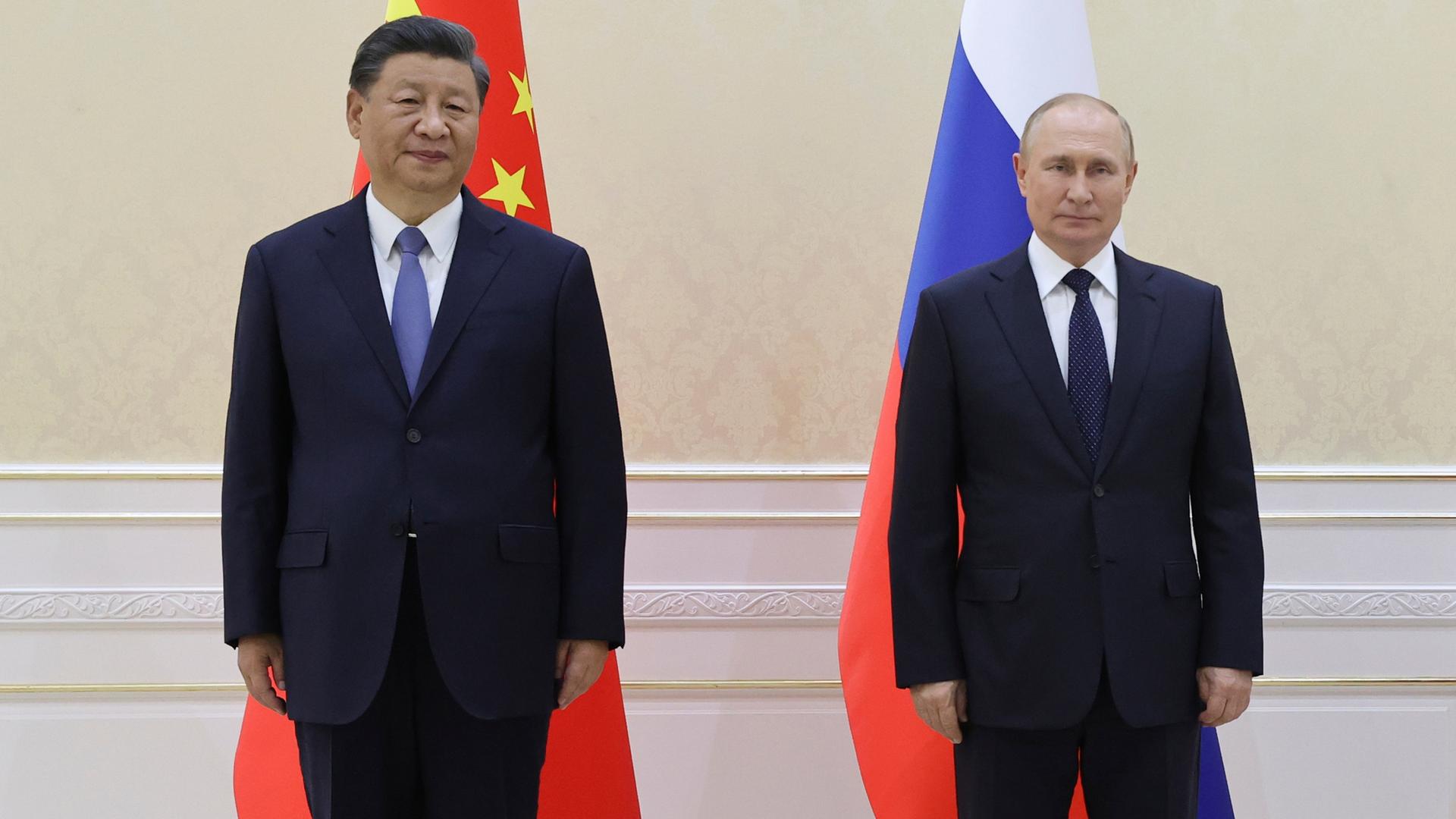 Chinas Staatschef Xi und Russlands Präsident Putin stehen vor den Fahnen ihrer Länder nebeneinander Chinas Staatschef Xi und Russlands Präsident Putin stehen vor den Fahnen ihrer Länder nebeneinander