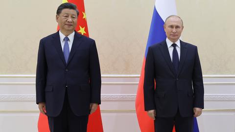 Chinas Staatschef Xi und Russlands Präsident Putin stehen vor den Fahnen ihrer Länder nebeneinander