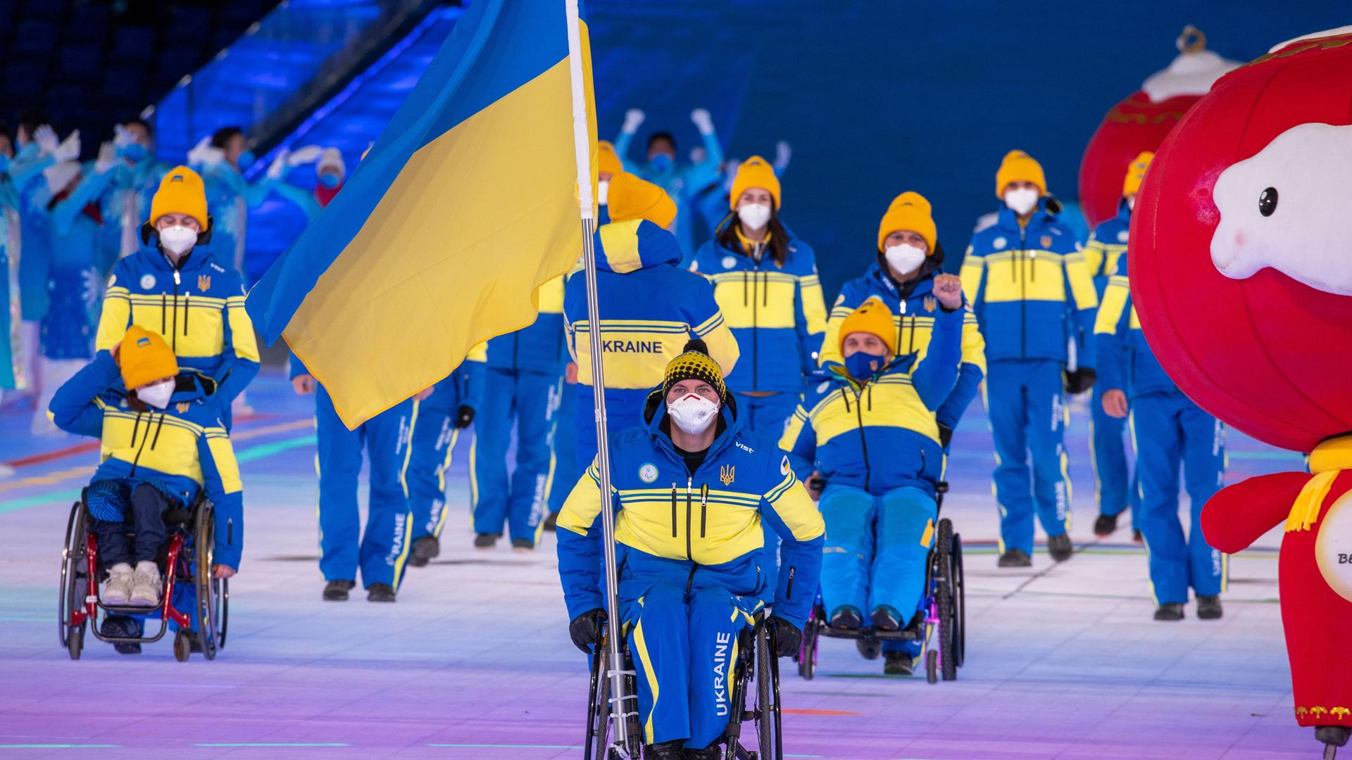 Maksym Yarovyi, Fahnenträger der Ukraine, zieht mit der Mannschaft aus der Ukraine bei der Eröffnungsfeier der Paralympics in das Stadion ein. Maksym Yarovyi, Fahnenträger der Ukraine, zieht mit der Mannschaft aus der Ukraine bei der Eröffnungsfeier der Paralympics in das Stadion ein.