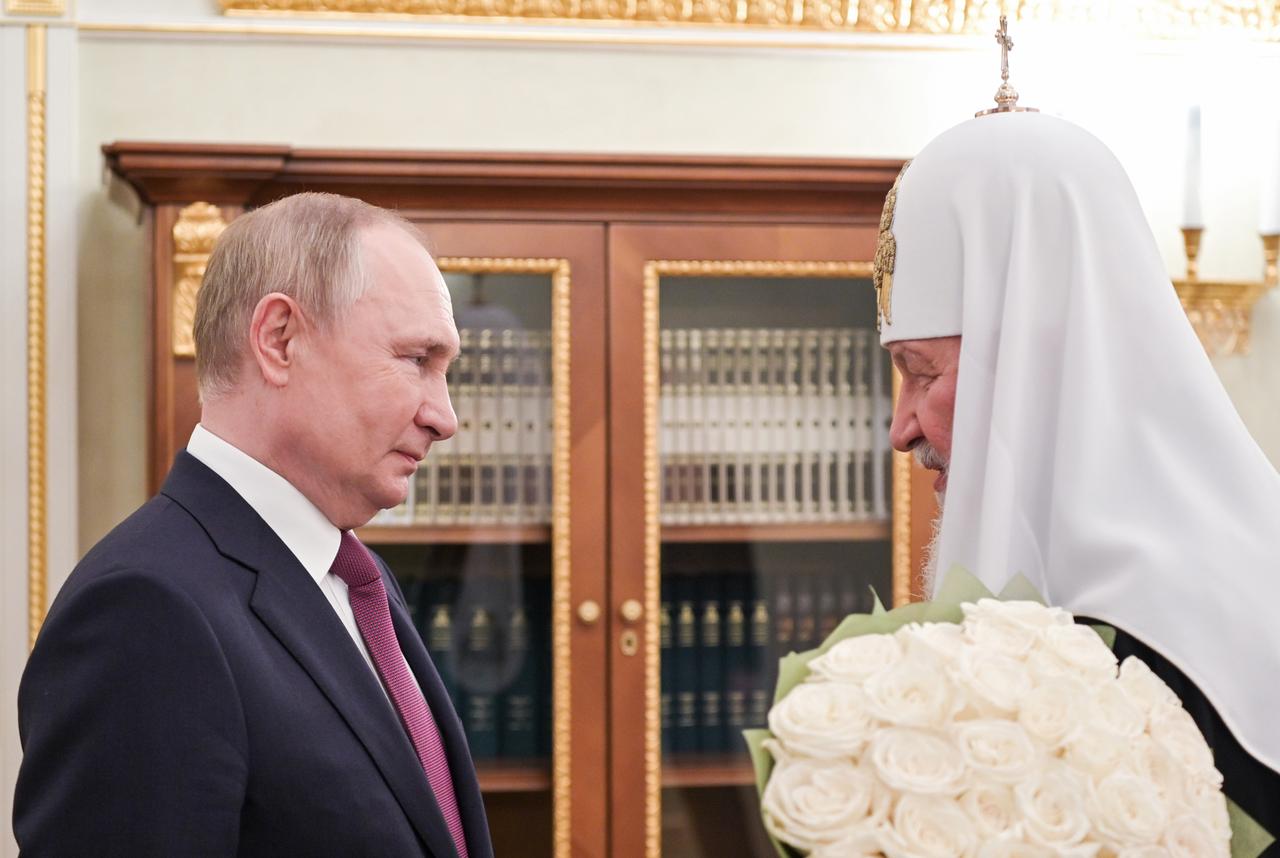 Russlands Präsident Wladimir Putin überreicht dem Oberhaupt der russisch-orthodoxen Kirche einen Blumenstrauß weißer Rosen.