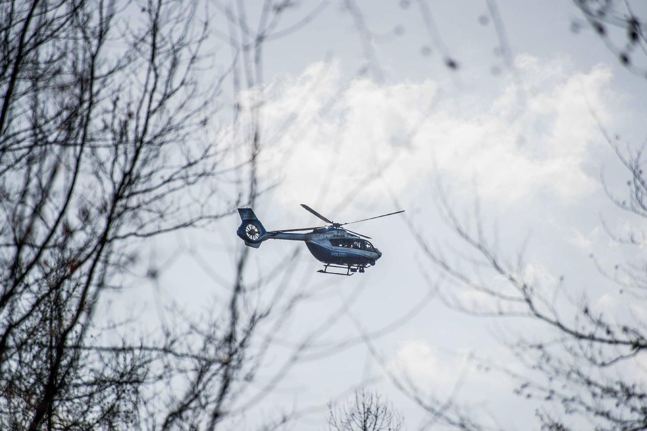 Ein Helikopter kreist bei einer Suchaktion über einem Wald.