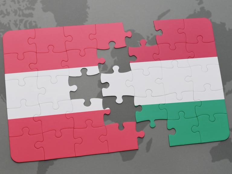 Blick auf ein Puzzle mit den Nationalflaggen von Österreich und Ungarn, die miteinander verbunden werden können. 