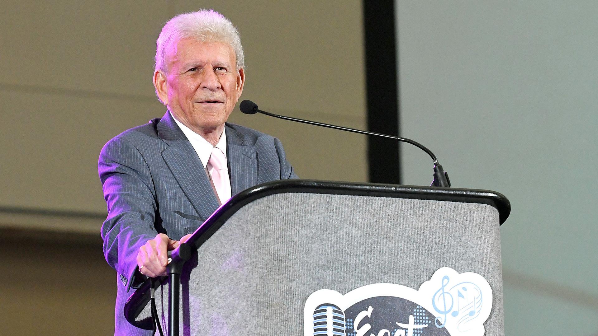 Der Sänger Bobby Rydell steht an einem Redner-Pult. Der Sänger Bobby Rydell steht an einem Redner-Pult.