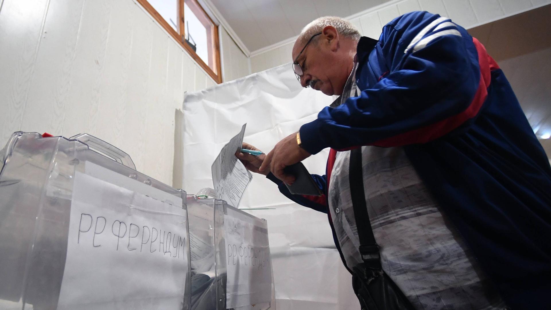 Ein Mann gibt seine Stimme in einem von Russland angesetzten Referendum ab  