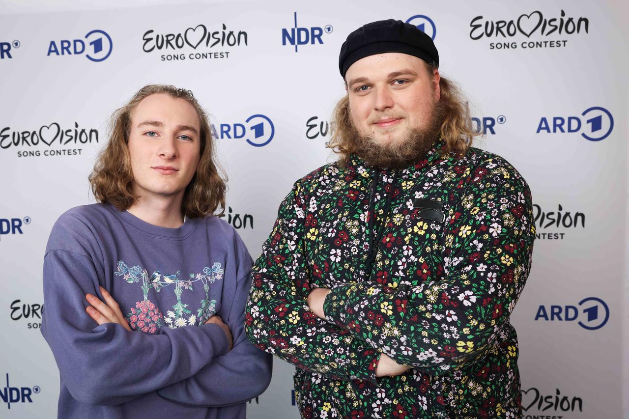 Die Musiker Maël & Jonas stehen mit verschränkten Armen vor der Kamera. Sie tragen flippige Klamotten und blicken freundlich in die Kamera. Die Musiker Maël & Jonas stehen mit verschränkten Armen vor der Kamera. Sie tragen flippige Klamotten und blicken freundlich in die Kamera.
