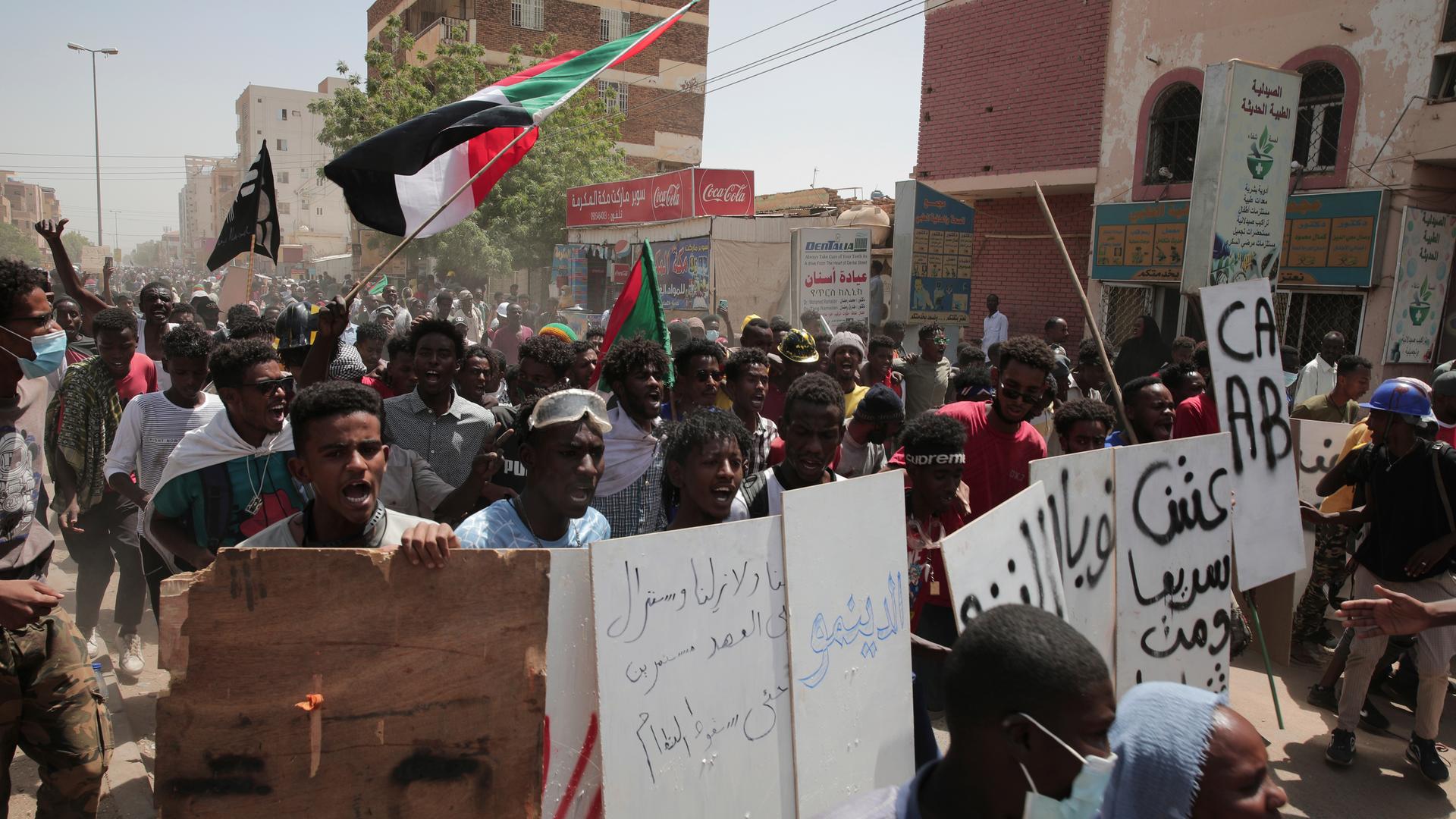 Protestierende in der sudanesischen Hauptstadt Khartoum im März 2022 mit Plakaten