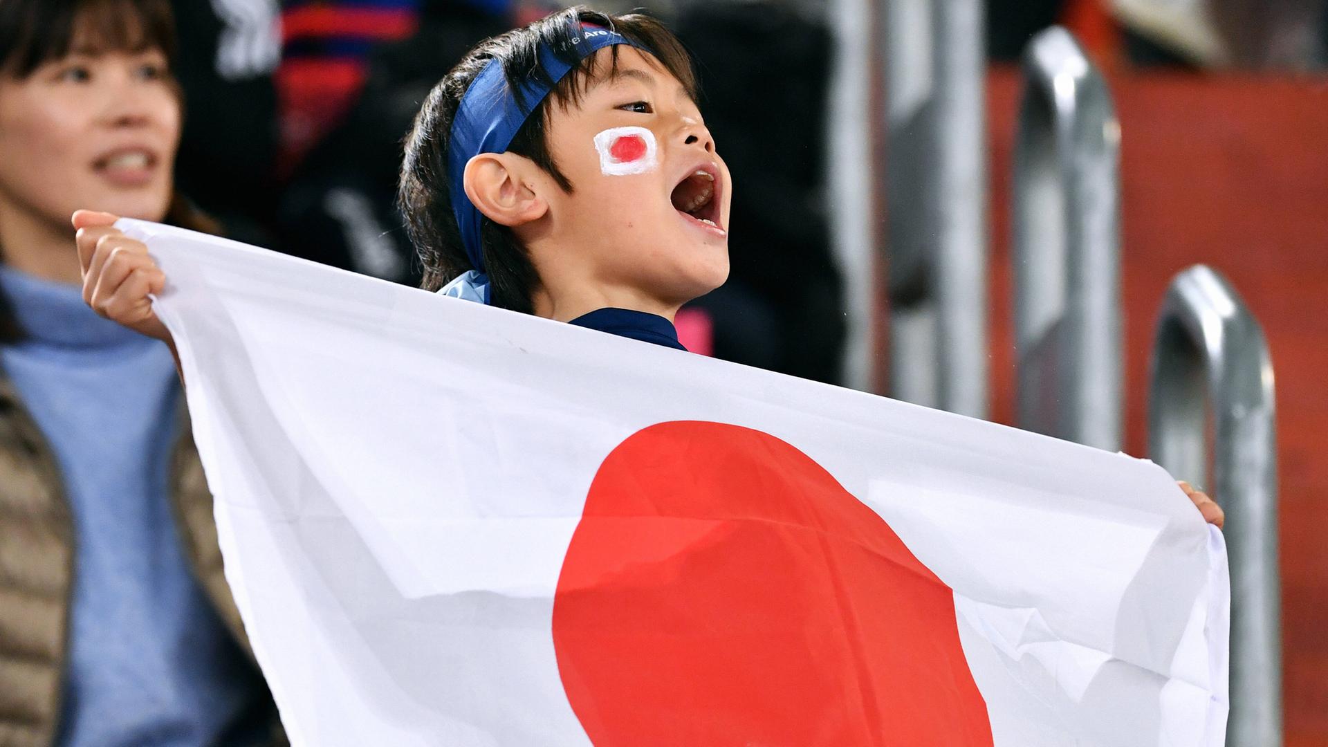 Ein junger Fan feuert die japanische FußballNationalmannschaft an. Ein junger Fan feuert die japanische FußballNationalmannschaft an.