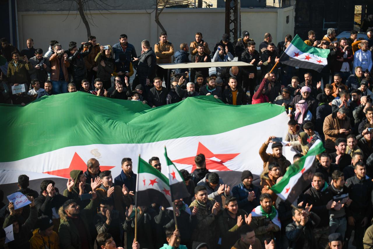 Demonstranten tragen eine große syrische Flagge: Sie demonstrieren gegen eine Annäherung zwischen der syrischen Regierung und Ankara. Demonstranten tragen eine große syrische Flagge: Sie demonstrieren gegen eine Annäherung zwischen der syrischen Regierung und Ankara.