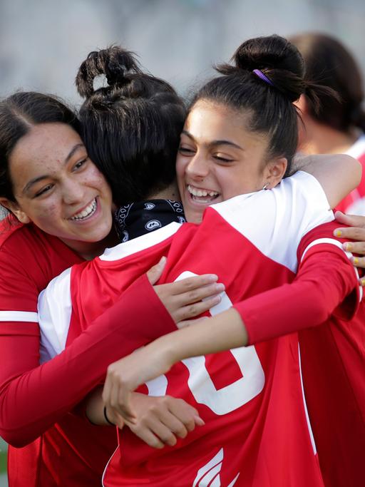 Members of the Afghanistan national girls soccer teams hug during a training session at a soccer pitch in Odivelas, outside Lisbon, Thursday, Sept. 30, 2021. The girls and their families arrived in Portugal Sept.19 after an international coalition came to their rescue. (AP Photo/Ana Brigida)