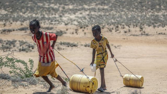 Dürre in Kenia im Mai 2022: Junge Mädchen ziehen Wasserbehälter, nachdem sie von einem Brunnen im Dorf Lomoputh im Norden Kenias zu ihren Hütten zurückkehren
