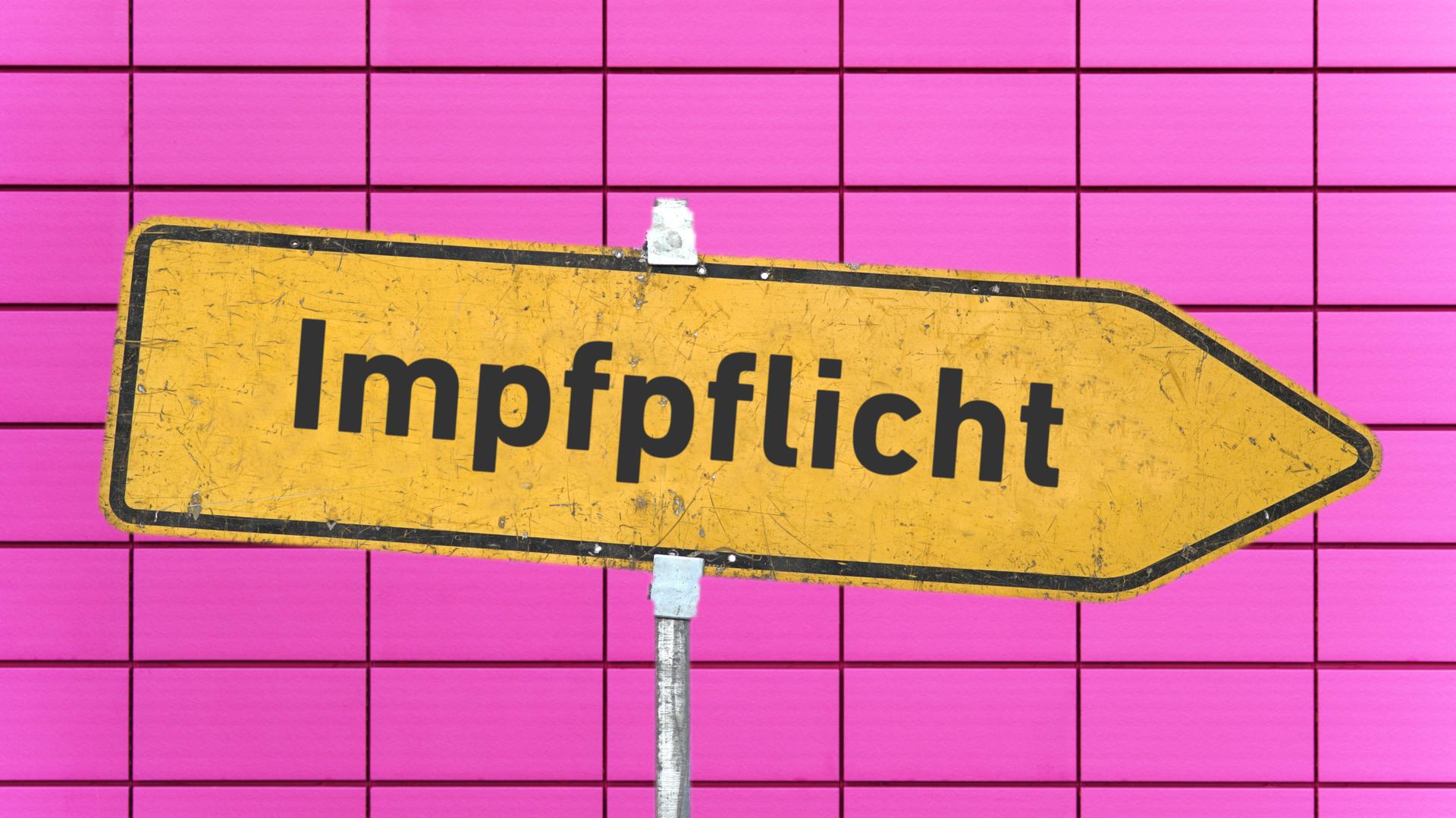 Ein gelbes, zerkratztes Hinweisschild mit der Aufschrift "Impfpflicht" vor einer rosa Kachelwand. Ein gelbes, zerkratztes Hinweisschild mit der Aufschrift "Impfpflicht" vor einer rosa Kachelwand.