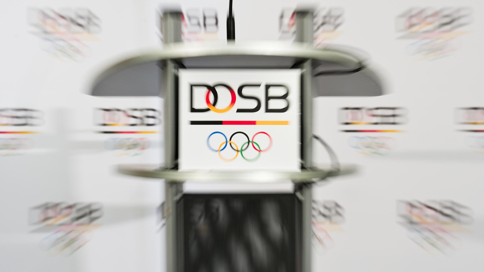 Das Logo des Deutschen Olympischen Sportbundes (DOSB) ist am 16.03.2015 in Frankfurt/Main (Hessen) vor dem Beginn einer Pressekonferenz zu sehen. (Aufnahme mit Zoomeffekt) Das Logo des Deutschen Olympischen Sportbundes (DOSB) ist am 16.03.2015 in Frankfurt/Main (Hessen) vor dem Beginn einer Pressekonferenz zu sehen. (Aufnahme mit Zoomeffekt)