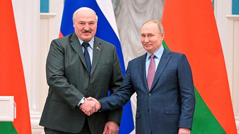 Alexander Lukaschenko und Wladimir Putin reichen sich die Hand und lächeln.
