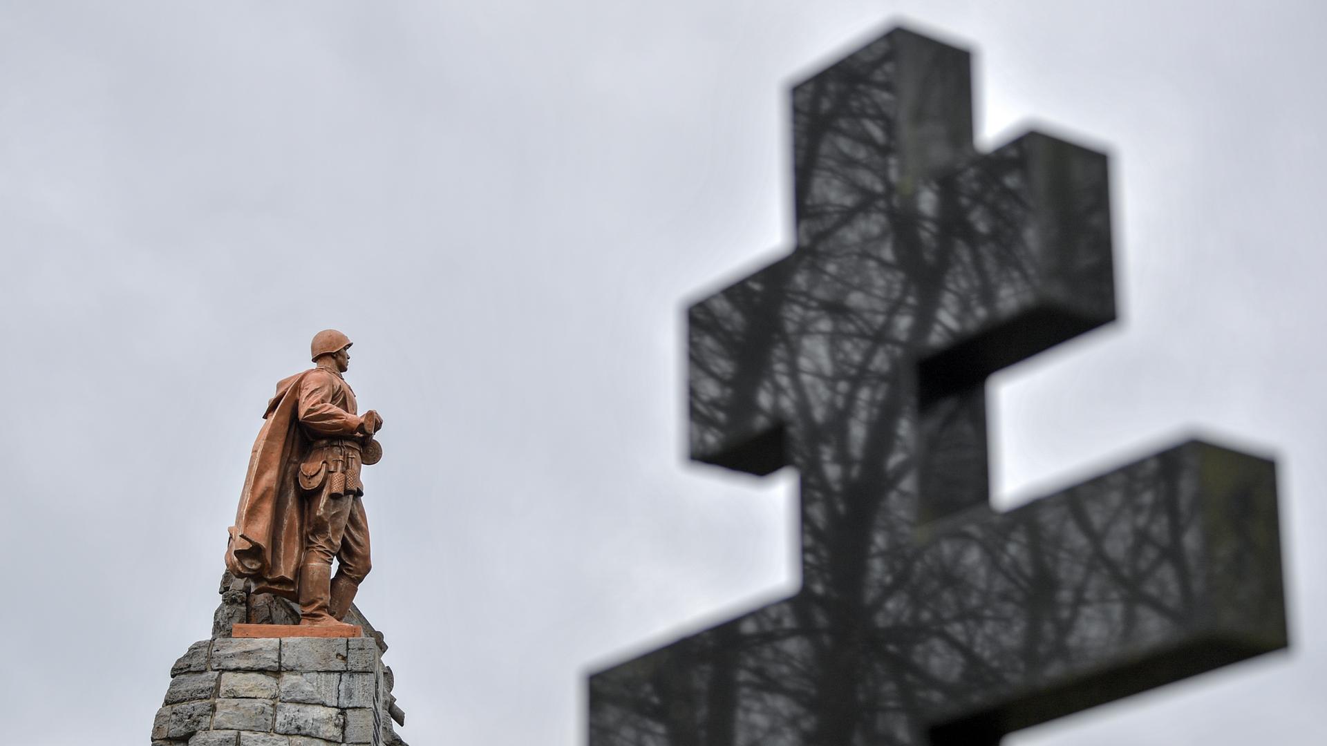 Die überlebensgroße Bronzeskulptur eines Soldaten der Roten Armee und ein russisch-orthodoxes Kreuz sind auf der Gedenkstätte Seelower Höhen zu sehen. 