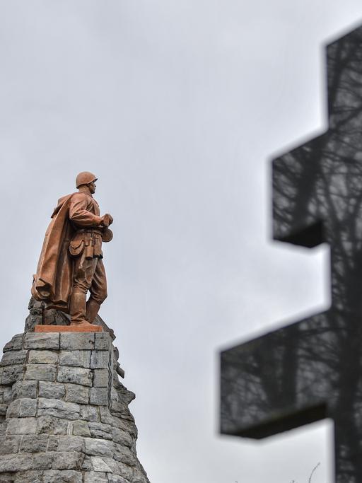 Die überlebensgroße Bronzeskulptur eines Soldaten der Roten Armee und ein russisch-orthodoxes Kreuz sind auf der Gedenkstätte Seelower Höhen zu sehen. 