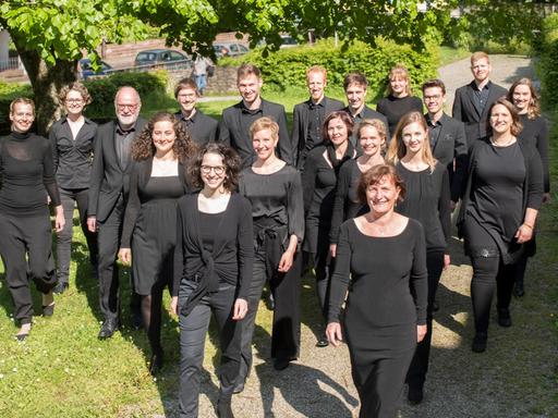 Gruppenbild des Chores in einem Park. Alle tragen schwarze Chorkleidung.