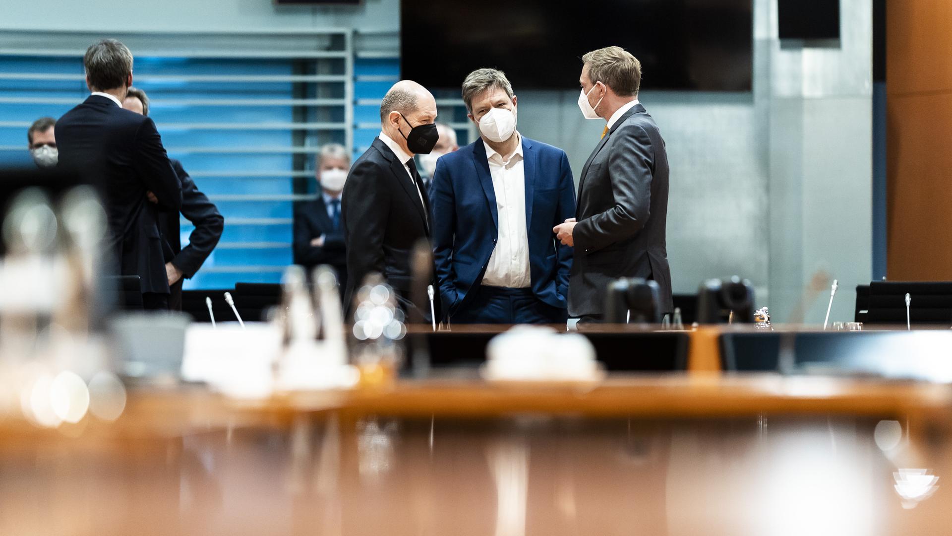 Olaf Scholz, Robert Habeck und Christian Lindner tragen Maske und und stehen im Bundeskanzleramt