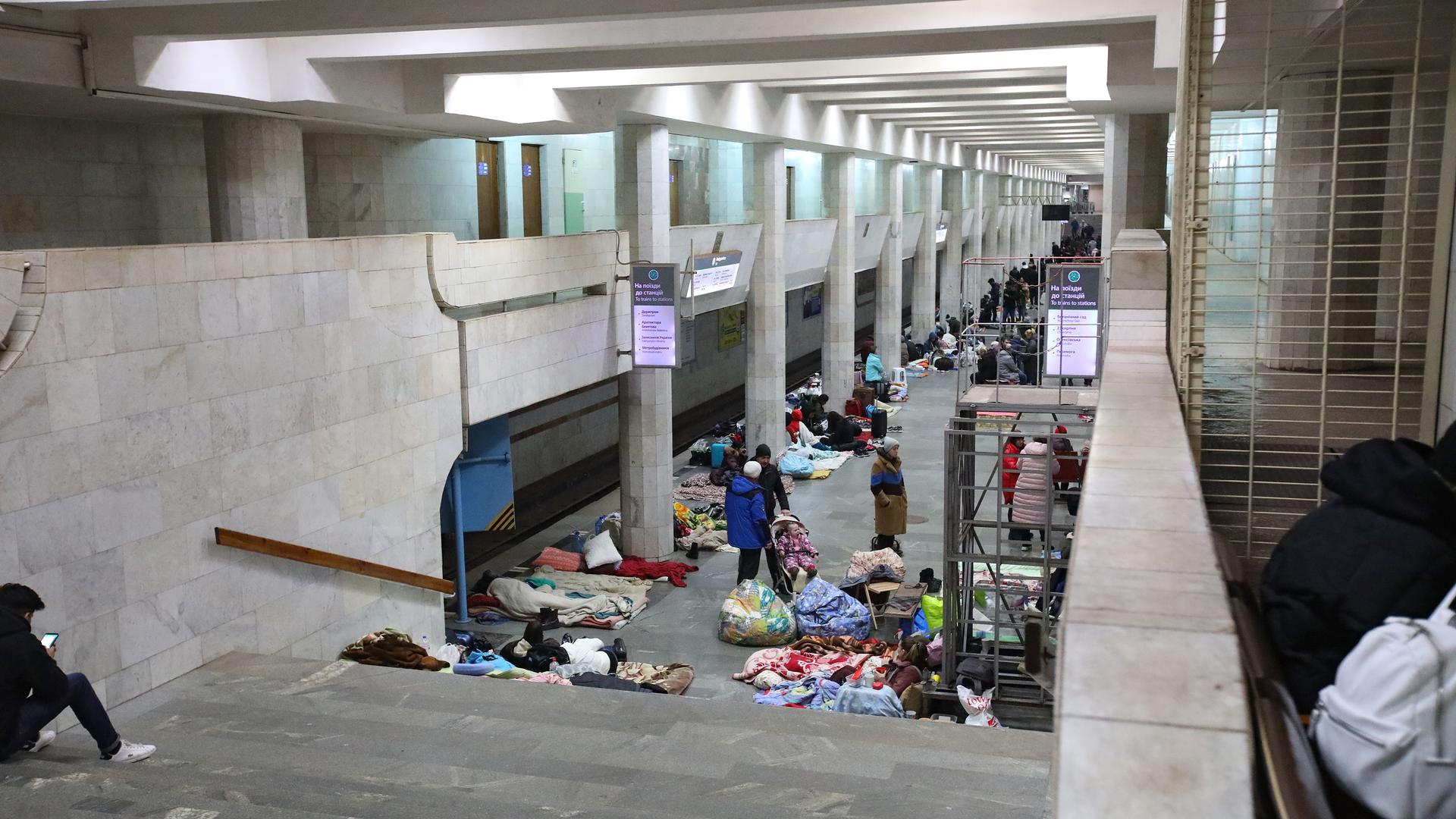 Menschen suchen in einer Metro-Station der Stadt Charkiw in der Ukraine Schutz vor Bombenangriffen.