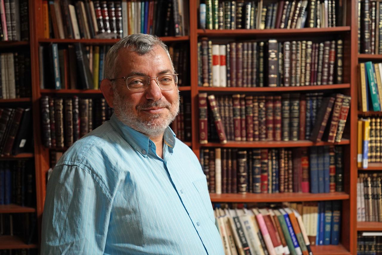 Der Historiker Benjamin Brown posiert vor einer Bücherwand für ein Foto.