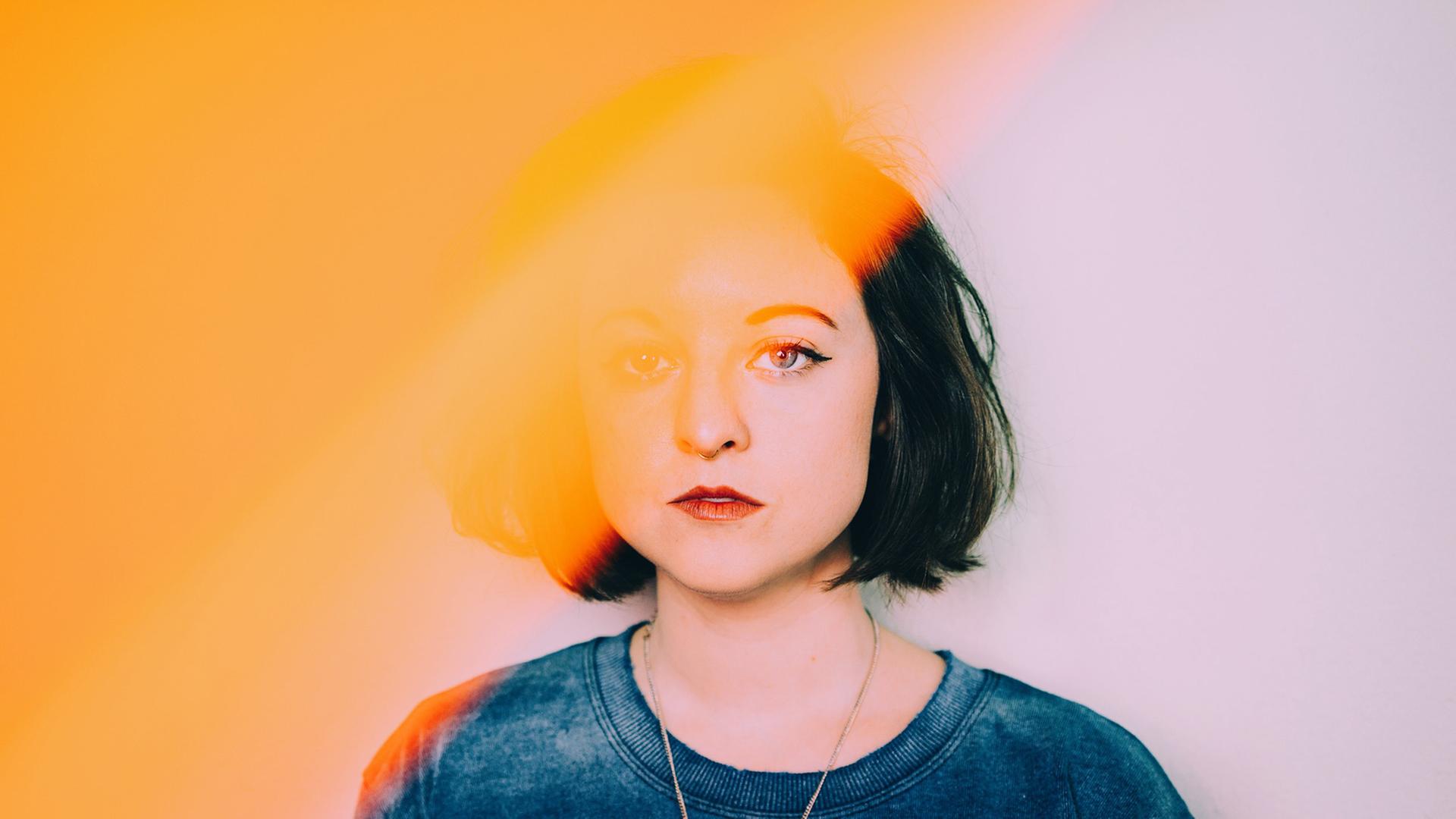 Mo begleiten Fantasiegefährten, beraten und beflügeln sie. Zu sehen: Das Portrait einer jungen Frau mit schwarzen Haaren. Die Hälfte des Bildes quer mit gelber Farbe "wie besprühlt", so dass man nur die Hälfte des Gesichts deutlich erkennen kann. Der Hintergrund ist in der anderen Hälfte des Bildes in zart lila Farbe. Mo begleiten Fantasiegefährten, beraten und beflügeln sie. Zu sehen: Das Portrait einer jungen Frau mit schwarzen Haaren. Die Hälfte des Bildes quer mit gelber Farbe "wie besprühlt", so dass man nur die Hälfte des Gesichts deutlich erkennen kann. Der Hintergrund ist in der anderen Hälfte des Bildes in zart lila Farbe.