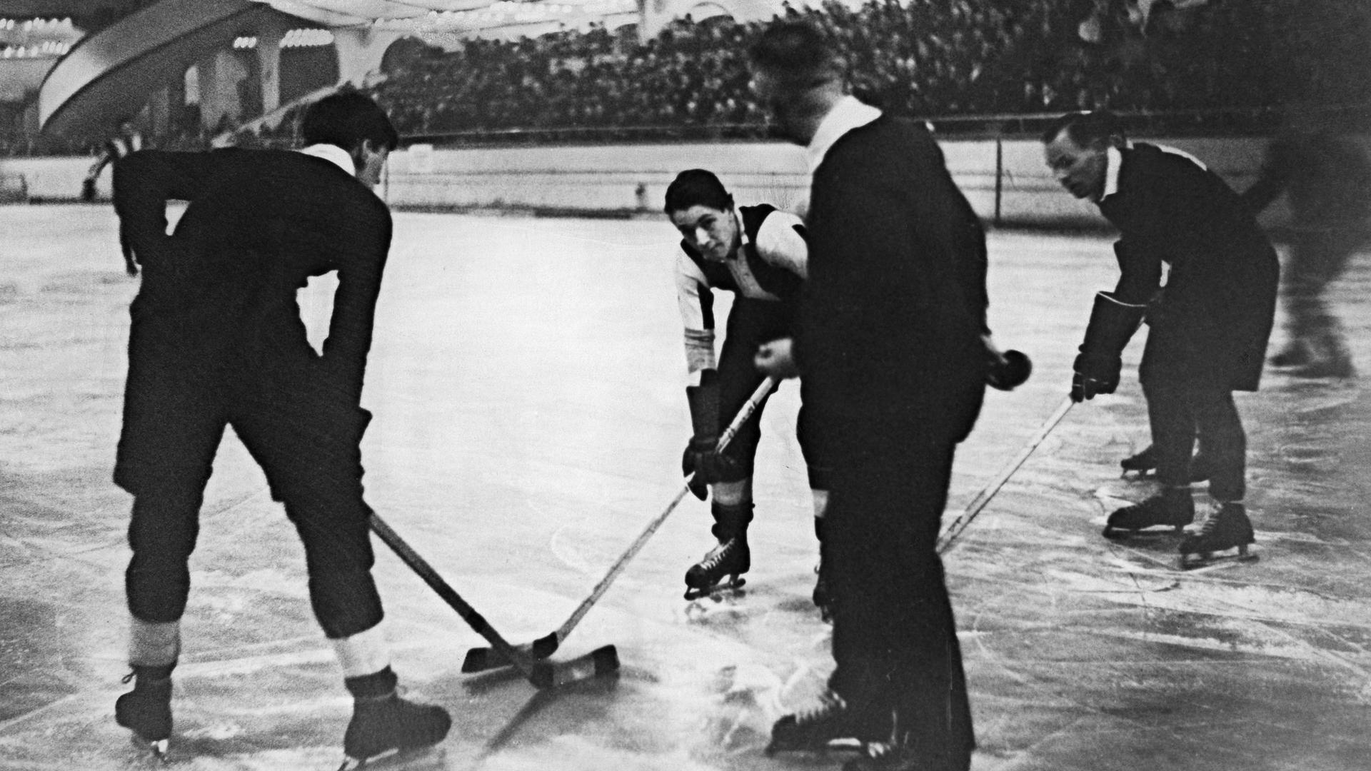 Schiedsrichter Himke wirft die Scheibe beim Spiel Berliner Schlittschuhclub gegen Eingland ein. Spieler: Ronny Castle (links), Rudi Ball (in der Mitte), Fair (rechts). Schiedsrichter Himke wirft die Scheibe beim Spiel Berliner Schlittschuhclub gegen Eingland ein. Spieler: Ronny Castle (links), Rudi Ball (in der Mitte), Fair (rechts).