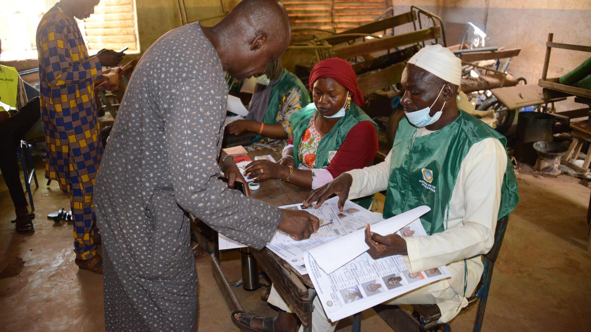 Zwei Männer haben in einem Wahllokal in Mali ihre Stimme für das Verfassungsreferendum abgegeben.
