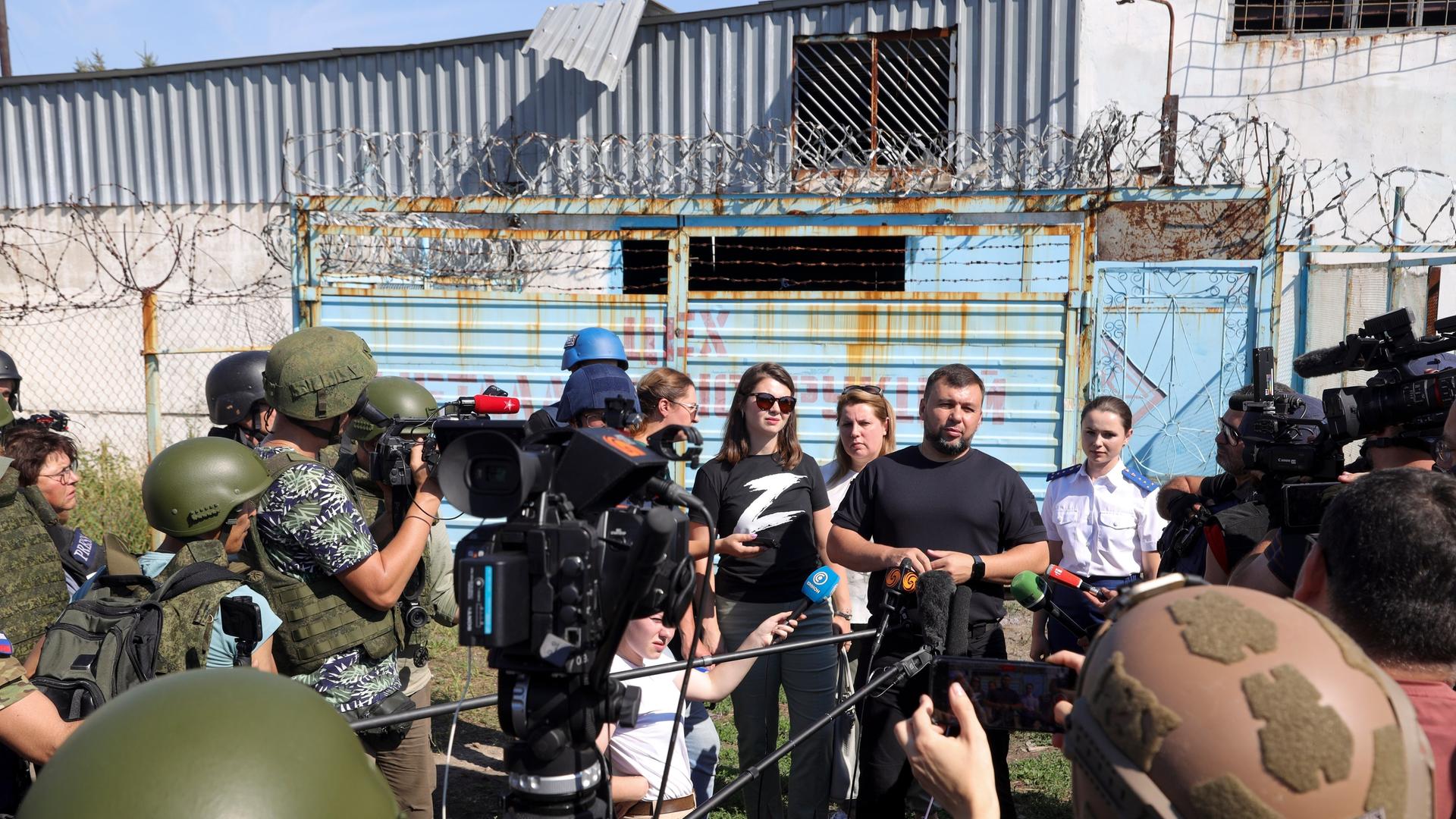 Denis Pushilin, the leader of the Donetsk People's Republic, background second right, speaks to foreign journalists at the destroyed barrack by following a strike on a prison housing POWs in Olenivka during a trip organized by the Russian Ministry of Defense, on the territory which is under the Government of the Donetsk People's Republic control, eastern Ukraine, Wednesday, Aug. 10, 2022. Russia has claimed that Ukraine's military used U.S.-supplied rocket launchers to strike the prison in Olenivka, a settlement controlled by the Moscow-backed Donetsk People's Republic. The Ukrainian military denied making any rocket or artillery strikes in Olenivka. (AP Photo) Denis Pushilin, the leader of the Donetsk People's Republic, background second right, speaks to foreign journalists at the destroyed barrack by following a strike on a prison housing POWs in Olenivka during a trip organized by the Russian Ministry of Defense, on the territory which is under the Government of the Donetsk People's Republic control, eastern Ukraine, Wednesday, Aug. 10, 2022. Russia has claimed that Ukraine's military used U.S.-supplied rocket launchers to strike the prison in Olenivka, a settlement controlled by the Moscow-backed Donetsk People's Republic. The Ukrainian military denied making any rocket or artillery strikes in Olenivka. (AP Photo)