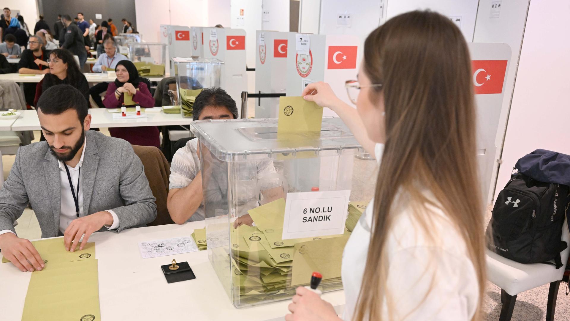 Eine Frau wirft einen Umschlag mit Ihrer Stimme zur Präsidentschaftswahl in der Türkei in einem Wahllokal in einem ehemaligen Kaufhaus in der Münchner Innenstadt in eine Wahlurne. Bei einer Stichwahl ums Präsidentenamt sind Türken in Bayern zur Wahl aufgerufen.