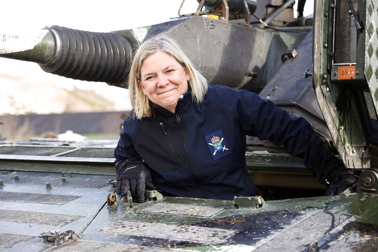 Eine blonde ältere Frau lehnt sich aus der Luke eines Panzers. Eine blonde ältere Frau lehnt sich aus der Luke eines Panzers.
