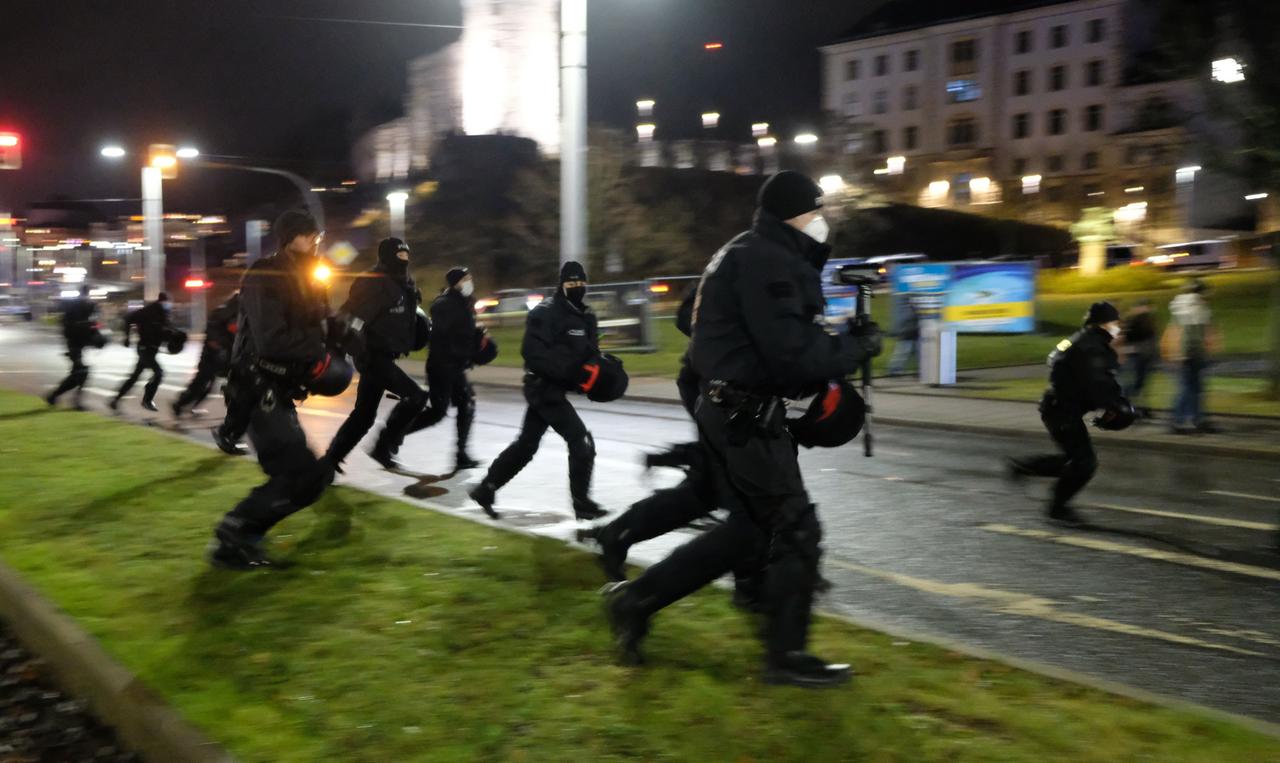 Polizisten laufen über einen Platz.