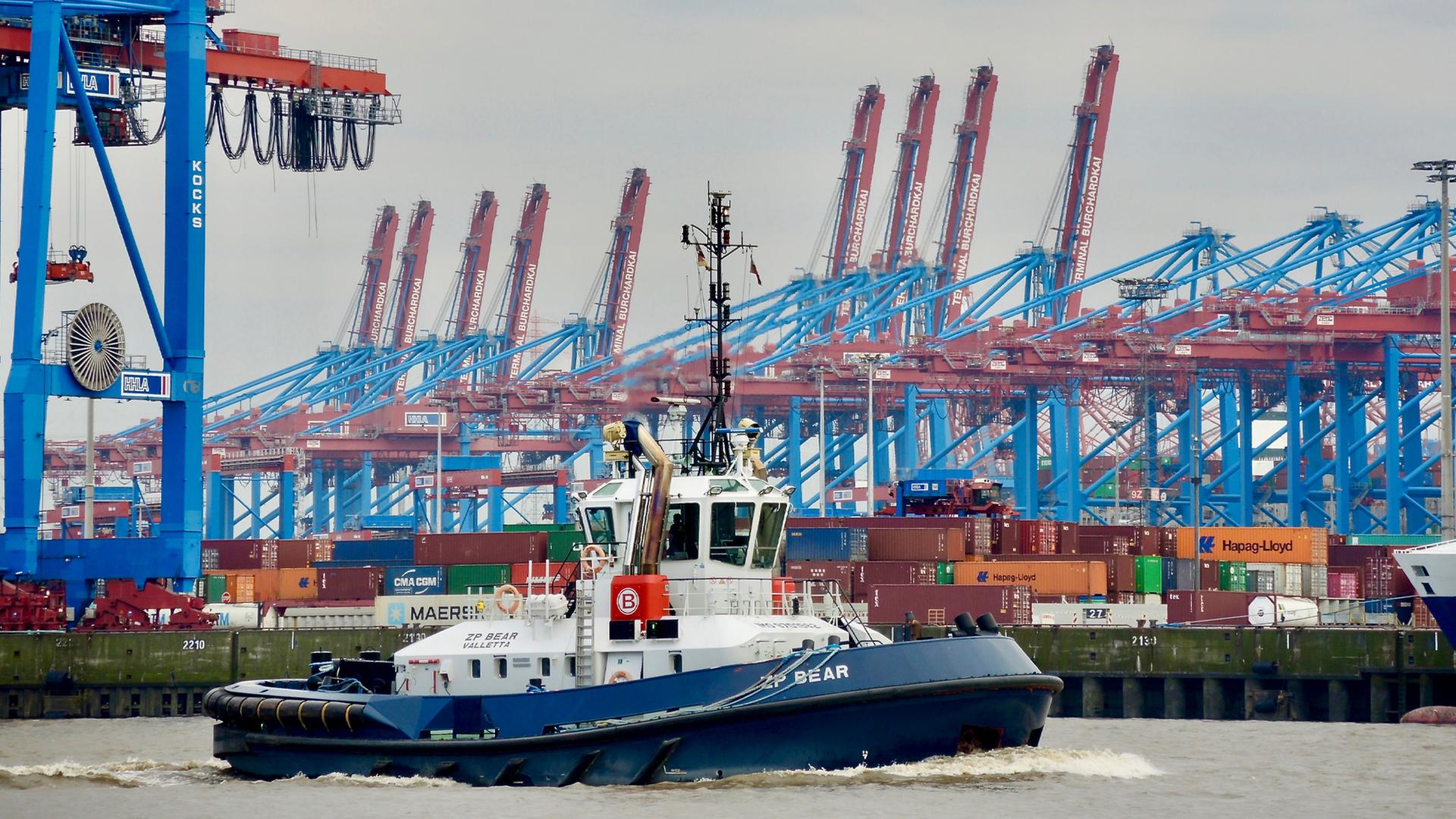 Ein Schlepper vor der Kulisse des Containerterminals Burchardkai im Hamburger Hafen, im Hintergrund die riesigen Portalbrücken-Kräne