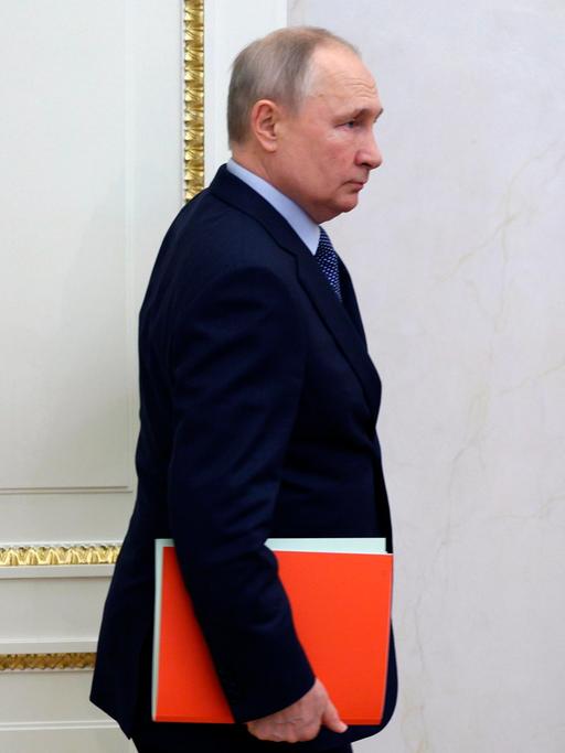 Der russische Präsident Wladimir Putin mit einer roten Mappe unter dem Arm, auf dem Weg zur einer Sitzung des Sicherheitsrats in Moskau. 