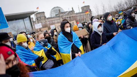 Menschen mit Ukraine-Flagge vor dem Reichstag in Berlin