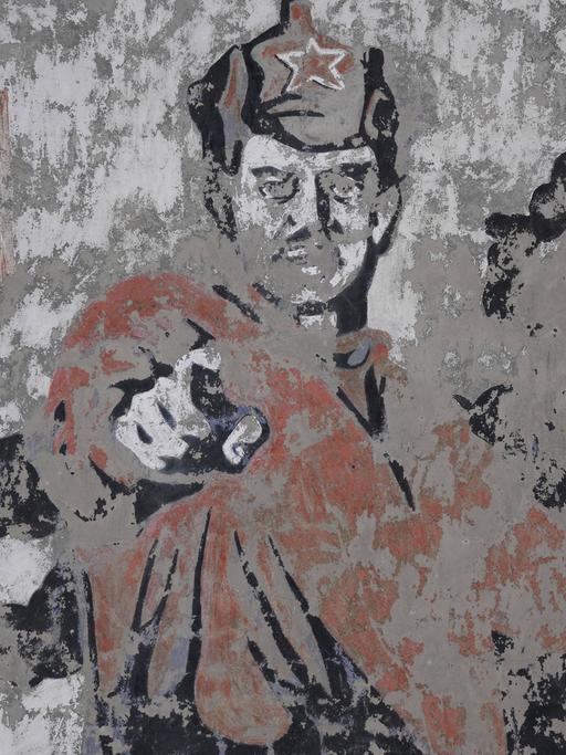 Ein verwittertes Wandbild mit einem sowjetischen Soldaten.