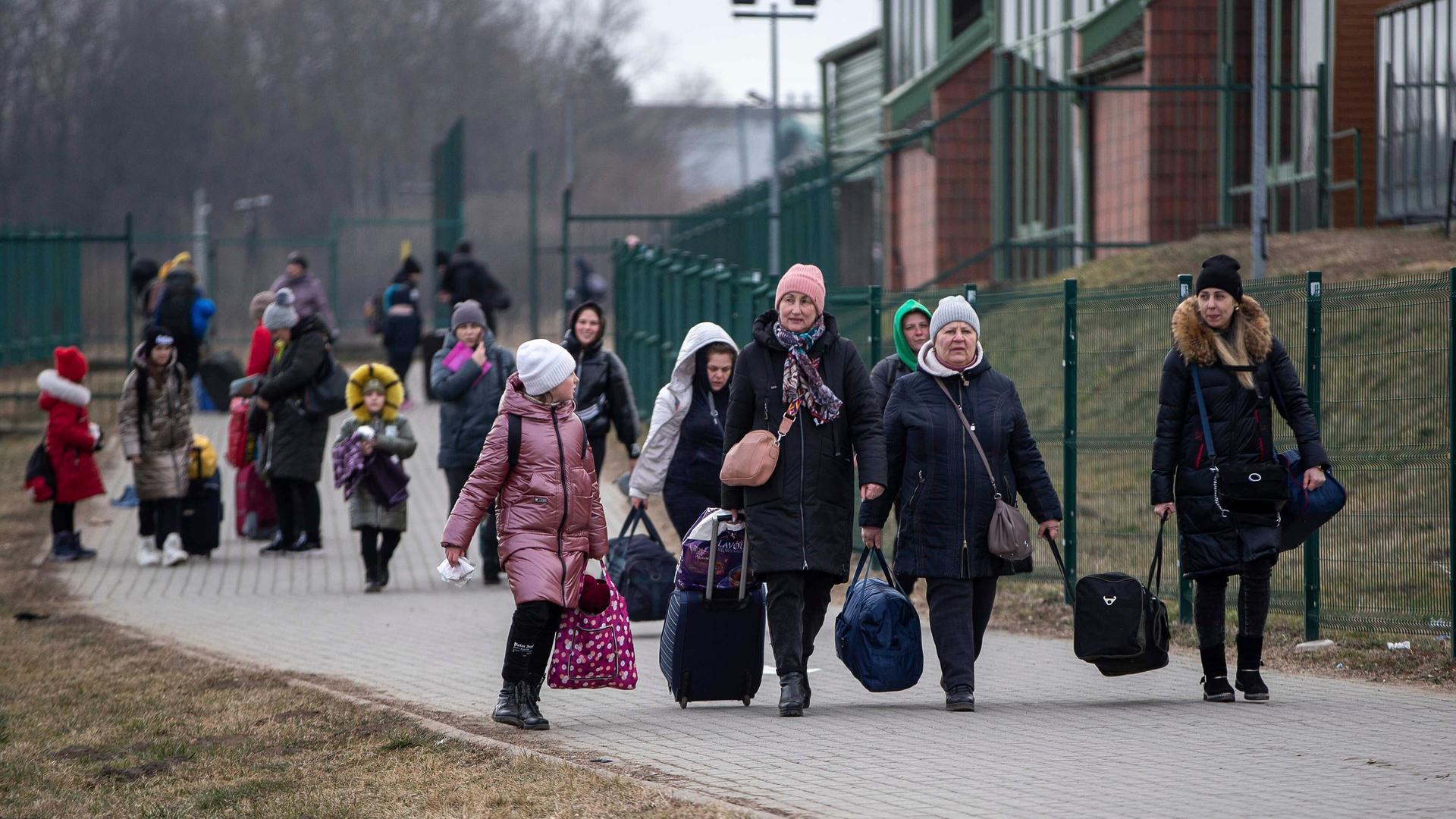 Frauen und Kinder mit Gepäck überqueren von der Ukraine aus die polnische Grenze in Medyka. Frauen und Kinder mit Gepäck überqueren von der Ukraine aus die polnische Grenze in Medyka.