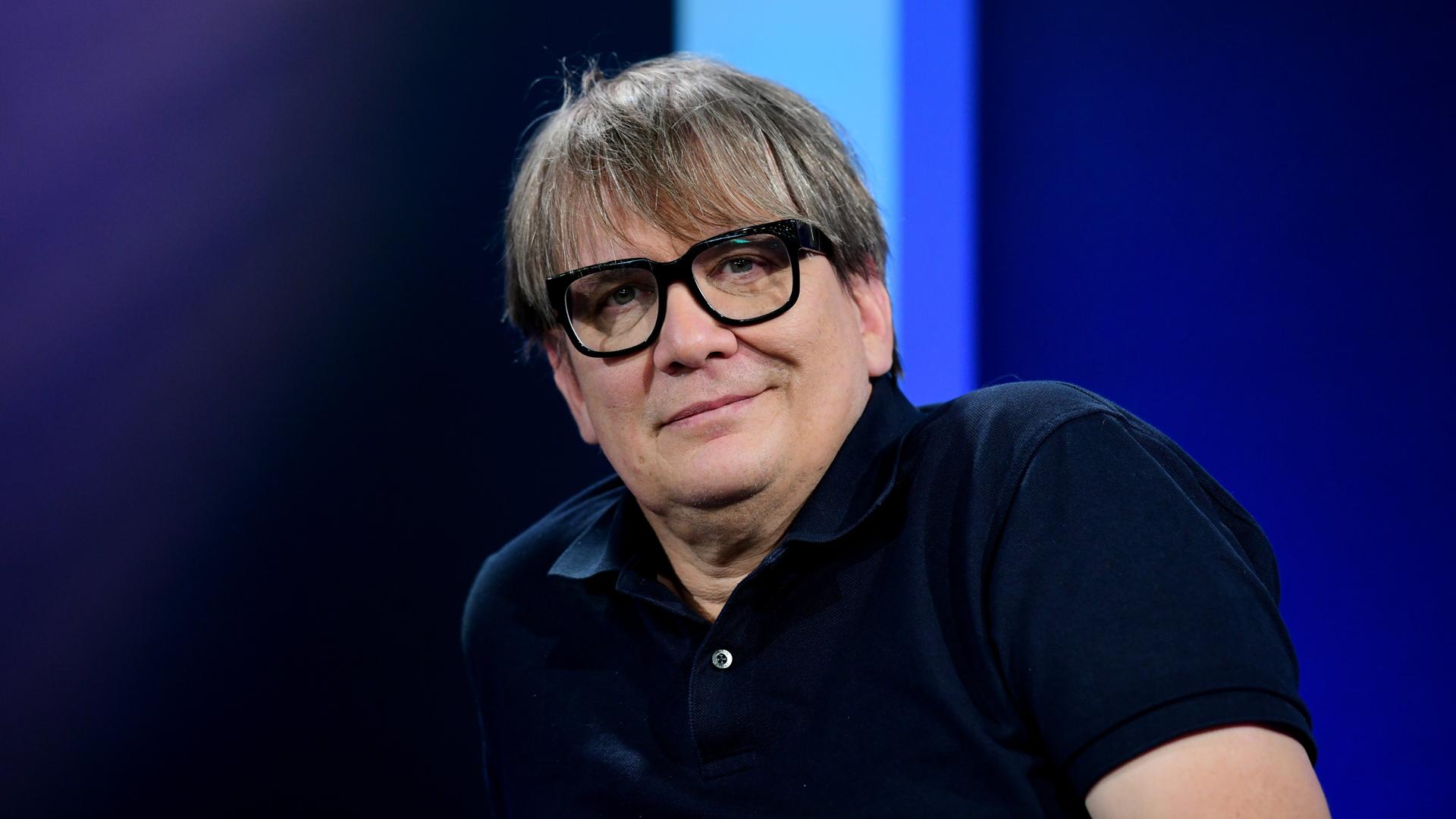 Sven Regener, schwarze Brille, schwarzes Shirt, schaut freundlich in die Kamera. Sven Regener, schwarze Brille, schwarzes Shirt, schaut freundlich in die Kamera.