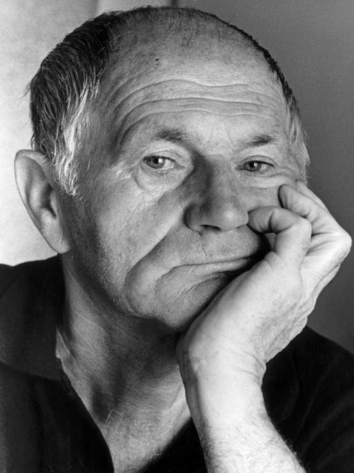 Der tschechische Schriftsteller Bohumil Hrabal (1984) blickt nachdenklich in die Kamera und hat den Kopf auf seine Hand gestützt.